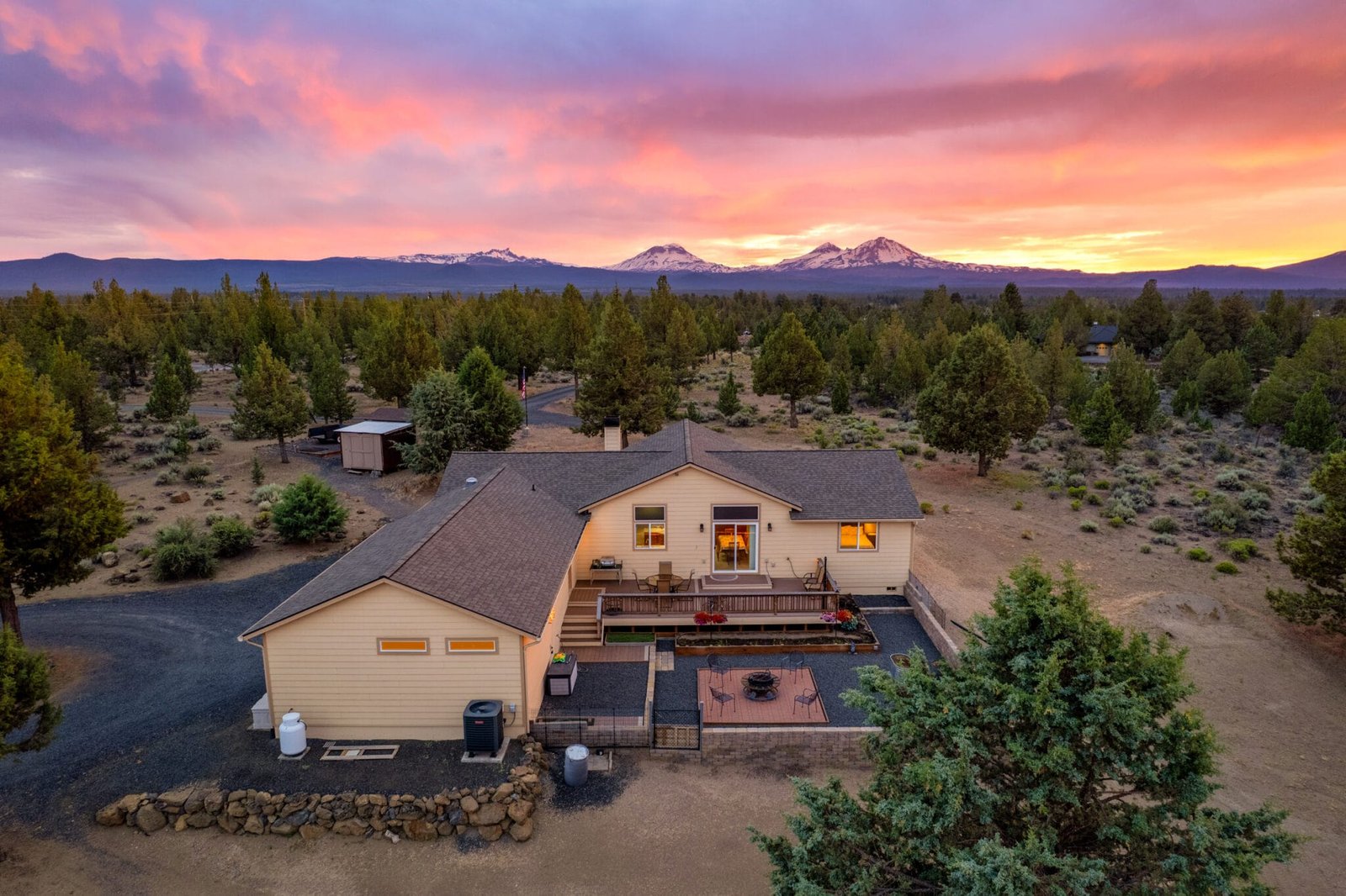 Bend real estate photographer twilight aerial of a Bend, Oregon home with the Cascade mountains at sunset