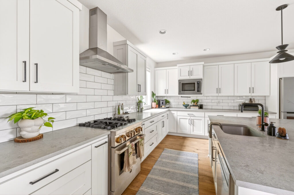 Bright white kitchen with center island, subway-tile backsplash and stainless range