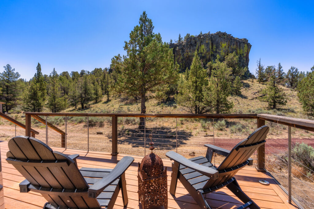 Deck chairs framing a rimrock butte and high desert landscape in Central Oregon