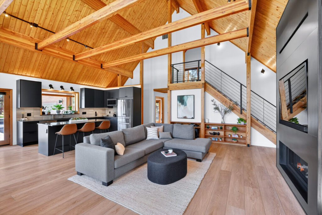 Modern open living space with timber beams and a floating staircase