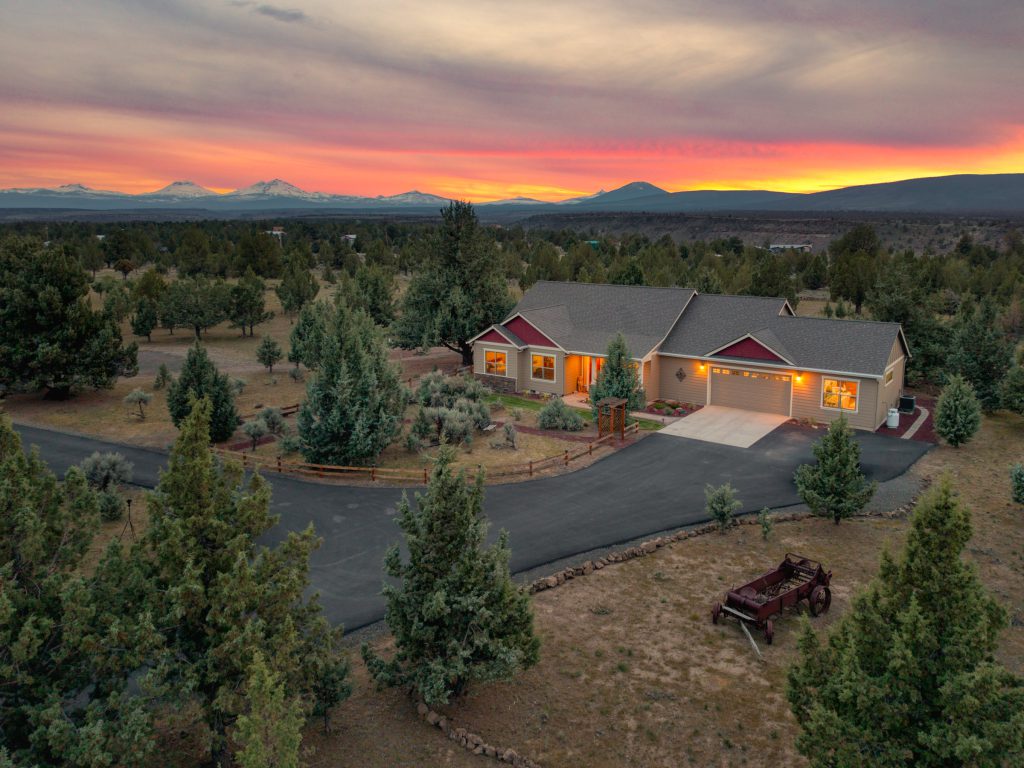 Aerial twilight of a Central Oregon ranch home with a Cascades sunset — Bend real estate photography by Wasim