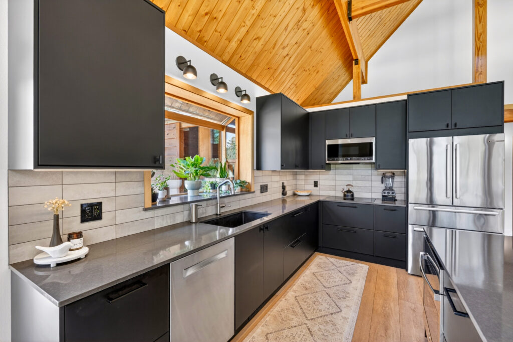 Kitchen with dark cabinets, vaulted knotty-pine ceiling and stainless appliances