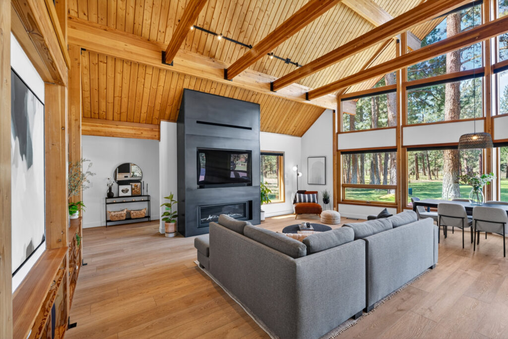 Living room with linear fireplace and forest-view windows in Bend, Oregon
