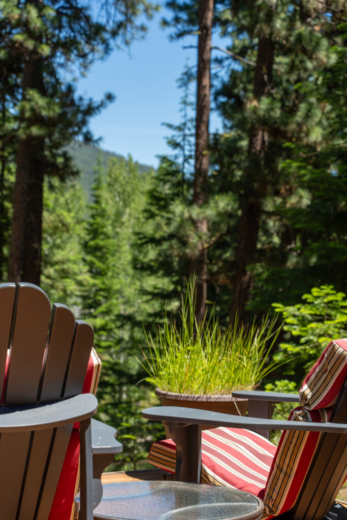 Deck seating with striped cushions overlooking a forested hillside in Central Oregon