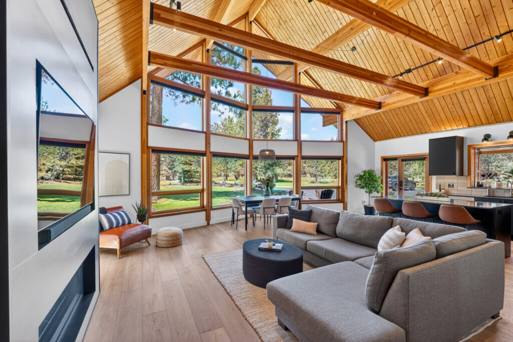 Vaulted great room with a wall of windows, sectional and forest views near Sisters, Oregon