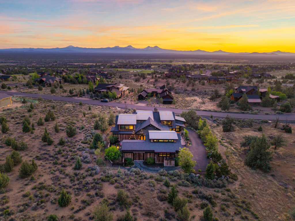 Aerial twilight view of a home with Cascade mountains and sunset in Central Oregon