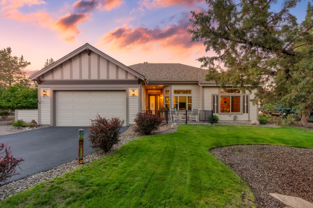 Twilight real estate photo of a Central Oregon craftsman home with a covered porch at sunset